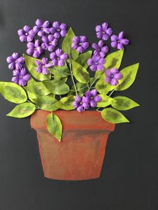 Artwork of purple flower s in terracotta pot made of recycled materials