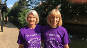 Volunteers Denise and Sandra in purple Saint Michael's t shirts